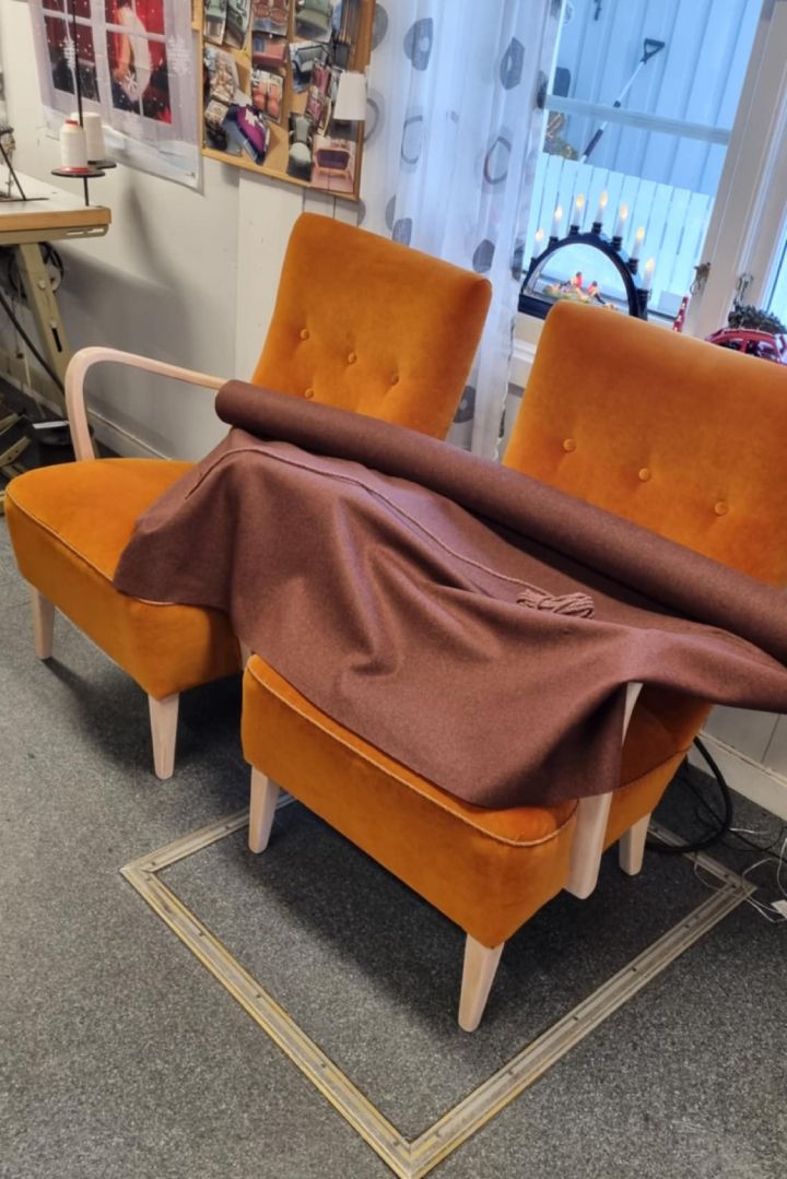To oransje lenestoler med nytt stoff lagt over, før